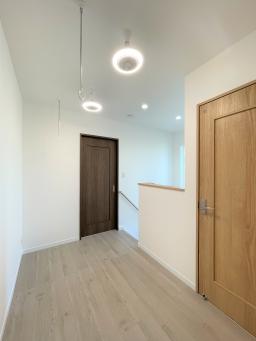 2階ホールはかなり広々です。お施主様支給のライトと共に。