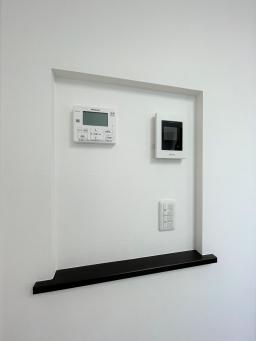 キッチンの横、各種モニターとスイッチをニッチ内に集約。